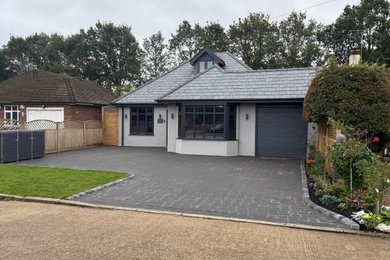 Design ideas for a large modern detached garage in Surrey with three or more cars.
