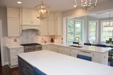 Example of a huge transitional u-shaped dark wood floor open concept kitchen design in DC Metro with an undermount sink, white cabinets, granite countertops, gray backsplash, ceramic backsplash, stainless steel appliances, an island and white countertops