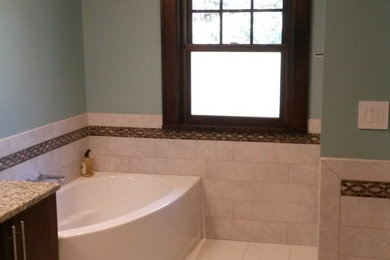 Inspiration for a mid-sized modern master brown tile and porcelain tile porcelain tile and beige floor bathroom remodel in Omaha with flat-panel cabinets, dark wood cabinets, a two-piece toilet, blue walls, an undermount sink and granite countertops