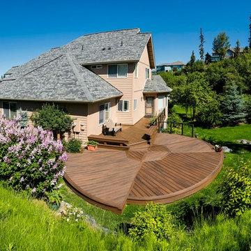 Round Trex deck with inlay, built in benches, and cable rail framed in aluminum