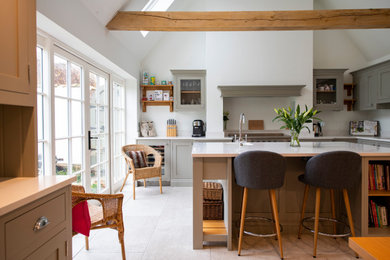 Design ideas for a large classic l-shaped kitchen/diner in Other with a single-bowl sink, shaker cabinets, quartz worktops, stainless steel appliances, porcelain flooring, an island, white worktops and exposed beams.