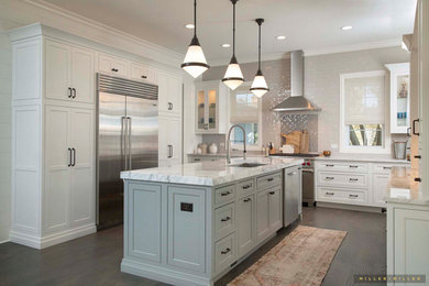 Inspiration for a transitional kitchen in Chicago with an undermount sink, shaker cabinets, white cabinets, white splashback, ceramic splashback, stainless steel appliances, with island, brown floor and white benchtop.