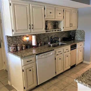 Small rustic galley kitchen pantry in Dallas with a submerged sink, raised-panel cabinets, beige cabinets, granite worktops, brown splashback, stone slab splashback, white appliances, porcelain flooring, beige floors and brown worktops.