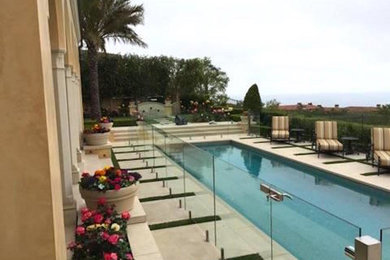 Diseño de piscinas y jacuzzis mediterráneos grandes rectangulares en patio trasero con suelo de hormigón estampado