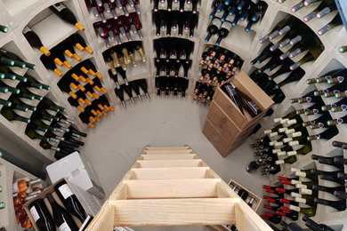 Exemple d'une cave à vin de taille moyenne avec des casiers et un sol gris.