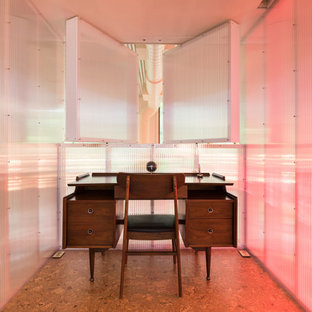 This is an example of a small modern study in New York with multi-coloured walls, cork flooring, no fireplace and a freestanding desk.