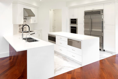 Open concept kitchen - large contemporary u-shaped porcelain tile and white floor open concept kitchen idea in Tampa with flat-panel cabinets, white cabinets, quartzite countertops, an island, an undermount sink, gray backsplash, mosaic tile backsplash, stainless steel appliances and white countertops