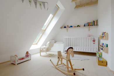 Großes Skandinavisches Kinderzimmer mit Spielecke, hellem Holzboden, weißem Boden, Holzdecke und Tapetenwänden in Hamburg