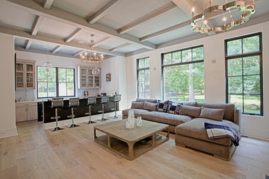 Photo of a large transitional open concept living room in New York with white walls, light hardwood floors, a standard fireplace, a plaster fireplace surround, no tv and beige floor.