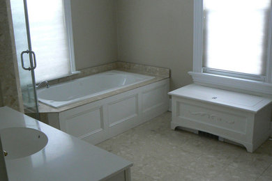 Bathroom - mid-sized master beige tile and stone tile ceramic tile bathroom idea in New York with a drop-in sink, louvered cabinets, white cabinets, granite countertops and beige walls