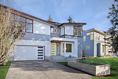 Example of a mid-sized minimalist multicolored two-story concrete fiberboard and clapboard house exterior design in Seattle with a butterfly roof, a shingle roof and a gray roof