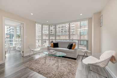 Mid-sized minimalist light wood floor and gray floor living room photo in Toronto with beige walls and a media wall
