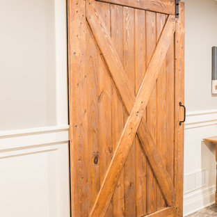 Modelo de sótano con puerta de estilo de casa de campo, de tamaño medio, con paredes grises y moqueta