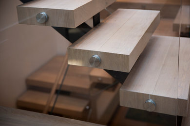 Wooden floating open, mixed material railing and shiplap wall staircase photo in San Francisco