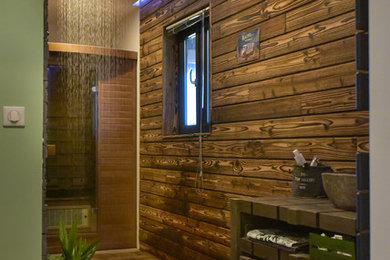 Cette image montre un sauna chalet de taille moyenne avec une douche ouverte, un mur marron, parquet clair, un lavabo de ferme, un sol marron et aucune cabine.