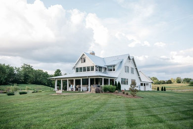 Large country white two-story exterior home idea in Other with a metal roof