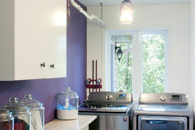 Mid-sized transitional galley ceramic tile utility room photo in Montreal with flat-panel cabinets, white cabinets, wood countertops, purple walls and a side-by-side washer/dryer