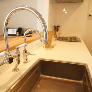 Klassisk inredning av ett mellanstort vit vitt kök, med en undermonterad diskho, skåp i shakerstil, turkosa skåp, träbänkskiva och vita vitvaror