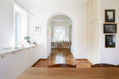Diseño de recibidores y pasillos contemporáneos de tamaño medio con paredes blancas y suelo de madera clara