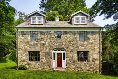 Elegant three-story stone exterior home photo in New York with a hip roof