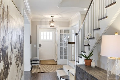 This is an example of a large transitional hallway in Minneapolis with white walls and dark hardwood floors.