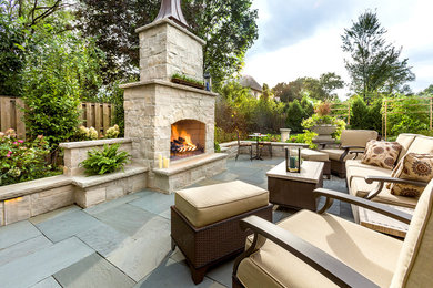 Inspiration for a traditional backyard patio in Chicago with a fire feature and natural stone pavers.