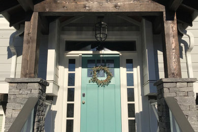 Large mountain style front porch photo in Vancouver with decking and a roof extension