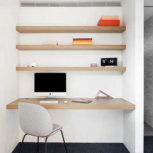 Modern study in Melbourne with white walls, carpet, a built-in desk and blue floors.