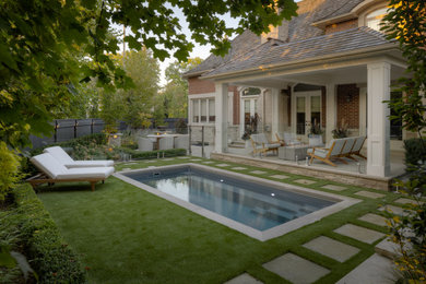 Pool landscaping - transitional backyard stone and rectangular pool landscaping idea in Toronto