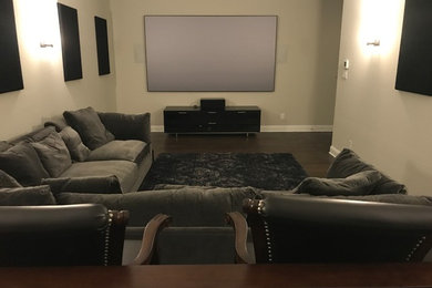Large elegant open concept dark wood floor and brown floor home theater photo in Dallas with beige walls and a projector screen