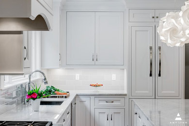 Example of a mid-sized transitional l-shaped medium tone wood floor and red floor eat-in kitchen design in Boston with an undermount sink, beaded inset cabinets, white cabinets, marble countertops, gray backsplash, porcelain backsplash, paneled appliances, an island and yellow countertops
