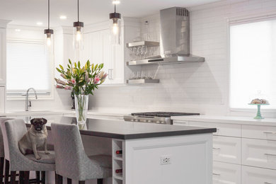 Large transitional l-shaped vinyl floor and white floor open concept kitchen photo in Toronto with an undermount sink, recessed-panel cabinets, white cabinets, quartz countertops, white backsplash, ceramic backsplash, stainless steel appliances, an island and white countertops