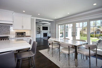 Eat-in kitchen - large brown floor eat-in kitchen idea in New York with recessed-panel cabinets, white cabinets, white backsplash, an island and white countertops
