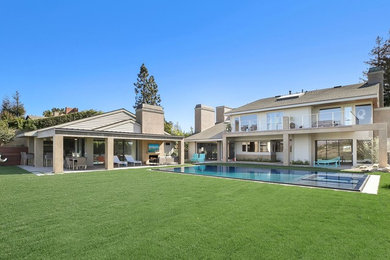 Inspiration for a large contemporary backyard concrete paver and rectangular infinity hot tub remodel in Orange County