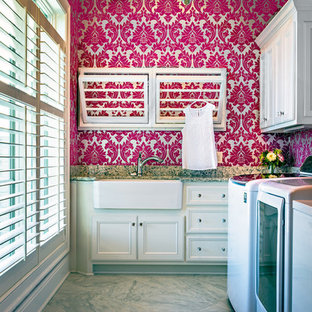 Inspiration for a medium sized traditional l-shaped utility room in Nashville with a belfast sink, recessed-panel cabinets, white cabinets, granite worktops, pink walls and a side by side washer and dryer.