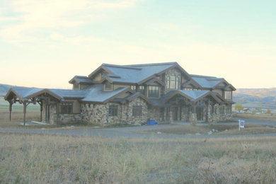 Example of a huge mountain style brown two-story mixed siding gable roof design in Other