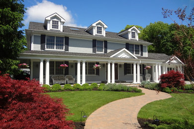 Example of a large classic gray two-story wood gable roof design in New York