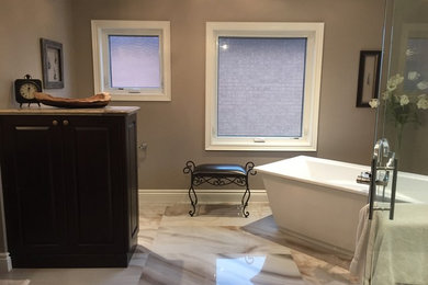 Inspiration for a mid-sized contemporary master brown tile and porcelain tile marble floor bathroom remodel in Toronto with raised-panel cabinets, dark wood cabinets, brown walls, an undermount sink, granite countertops and a one-piece toilet