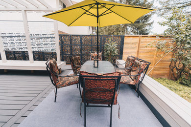 Deck - mid-sized contemporary backyard deck idea in Vancouver with a pergola