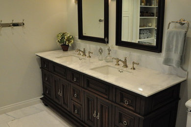 Example of a mid-sized transitional master white tile and stone tile marble floor corner shower design in Phoenix with furniture-like cabinets, dark wood cabinets, an undermount tub, a two-piece toilet, white walls, an undermount sink and marble countertops
