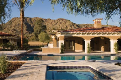 Large tuscan backyard concrete paver patio photo in Phoenix