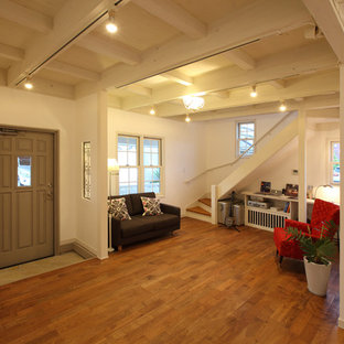 他の地域の片開きドアビーチスタイルのおしゃれな玄関 (白い壁、無垢フローリング、グレーのドア、茶色い床) の写真