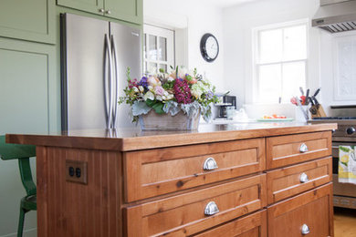 Mid-sized u-shaped open concept kitchen photo in Boston with an undermount sink, shaker cabinets, green cabinets, quartz countertops, white backsplash, stainless steel appliances and an island