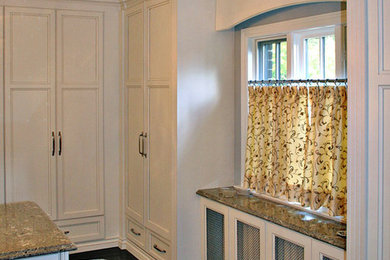 Inspiration for a large timeless gender-neutral dark wood floor dressing room remodel in Toronto with recessed-panel cabinets and white cabinets