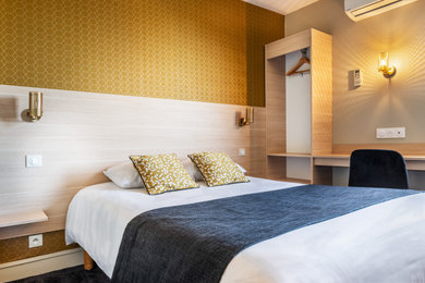 他の地域にある中くらいなコンテンポラリースタイルのおしゃれな主寝室 (黄色い壁、カーペット敷き、黒い床、壁紙)