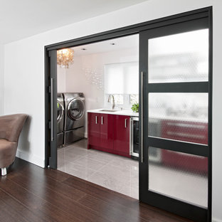 Inspiration for a contemporary utility room in Ottawa with red cabinets, white walls, grey floors and white worktops.