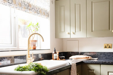 Inspiration for a large classic l-shaped enclosed kitchen in Other with a double-bowl sink, shaker cabinets, green cabinets, composite countertops, stainless steel appliances, vinyl flooring, an island, brown floors, black worktops, a drop ceiling and a chimney breast.
