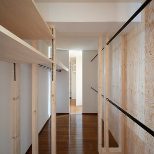 Aménagement d'un dressing et rangement moderne avec un sol en contreplaqué et un plafond en papier peint.