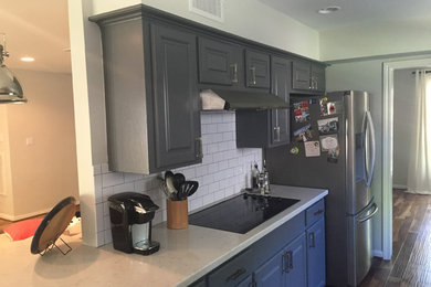 Example of a cottage kitchen design in Houston with gray cabinets, solid surface countertops and subway tile backsplash