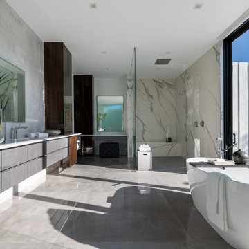 Modern bathroom with a sink and mirror on the wall, shower, and trendy bathtub